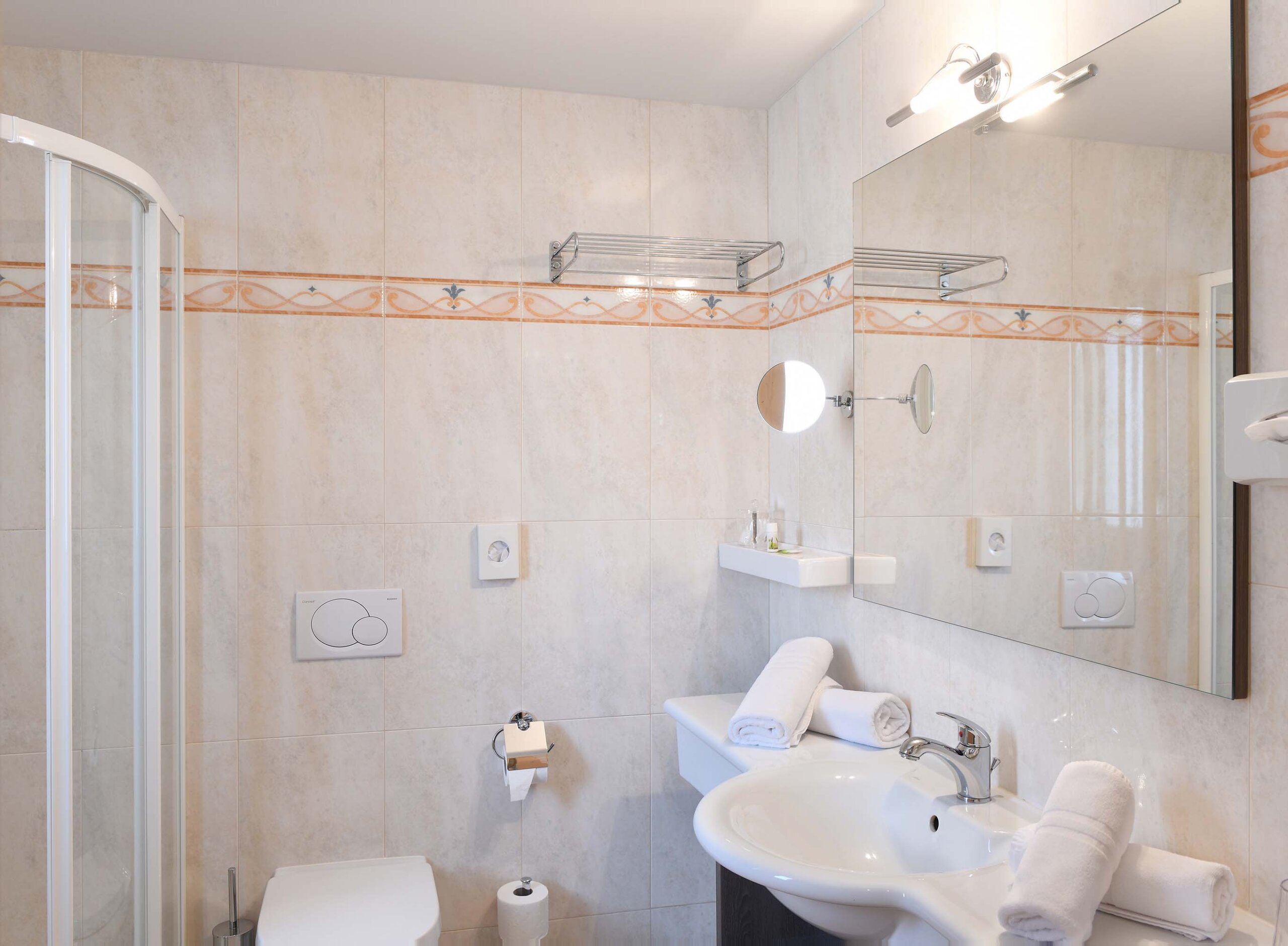 Badezimmer mit orangen Ornamenten auf den Fließen - Hotel das stachelburg