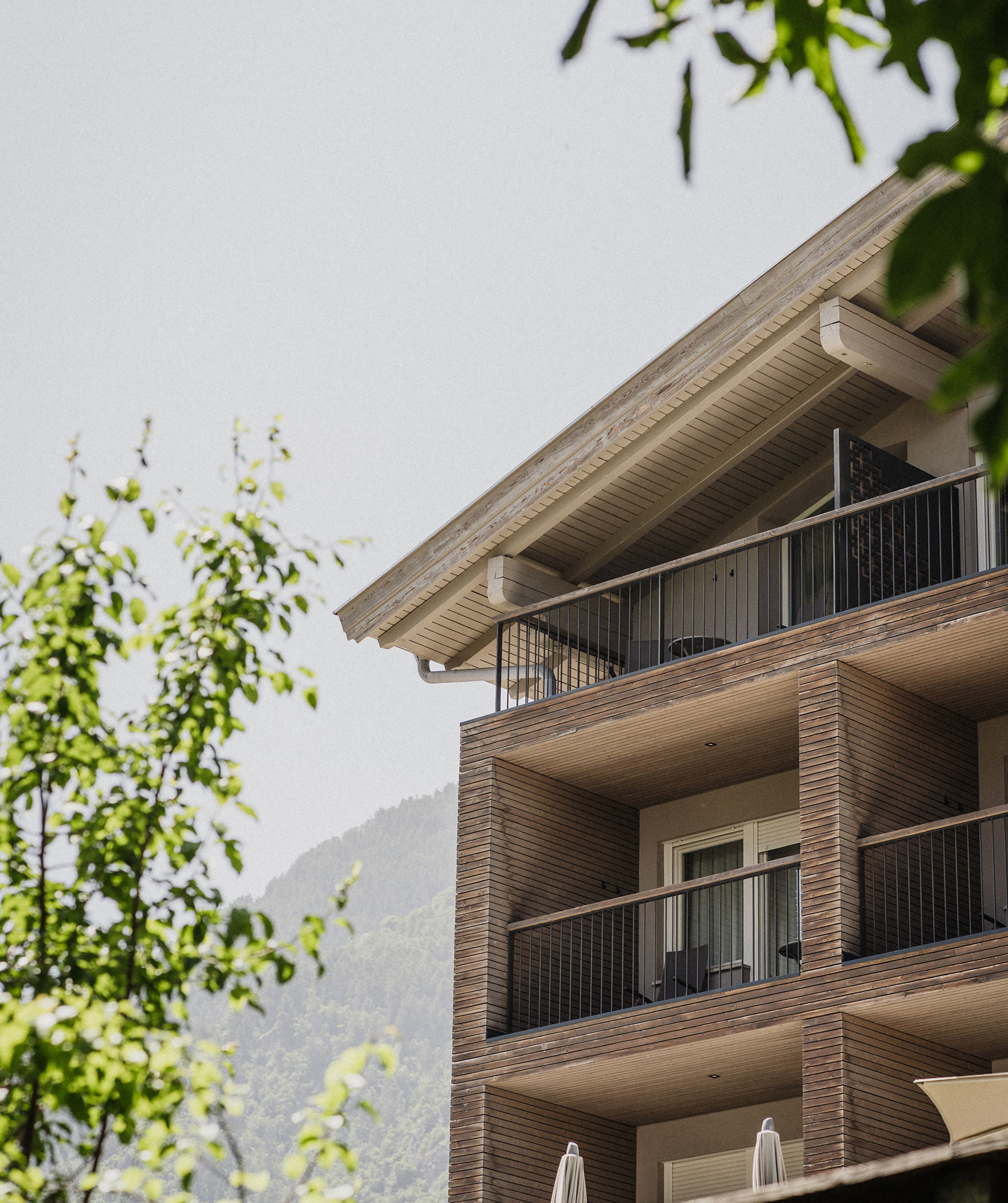 Hotel von außen Balkon ist zu sehen und Blätter im Vordergrund