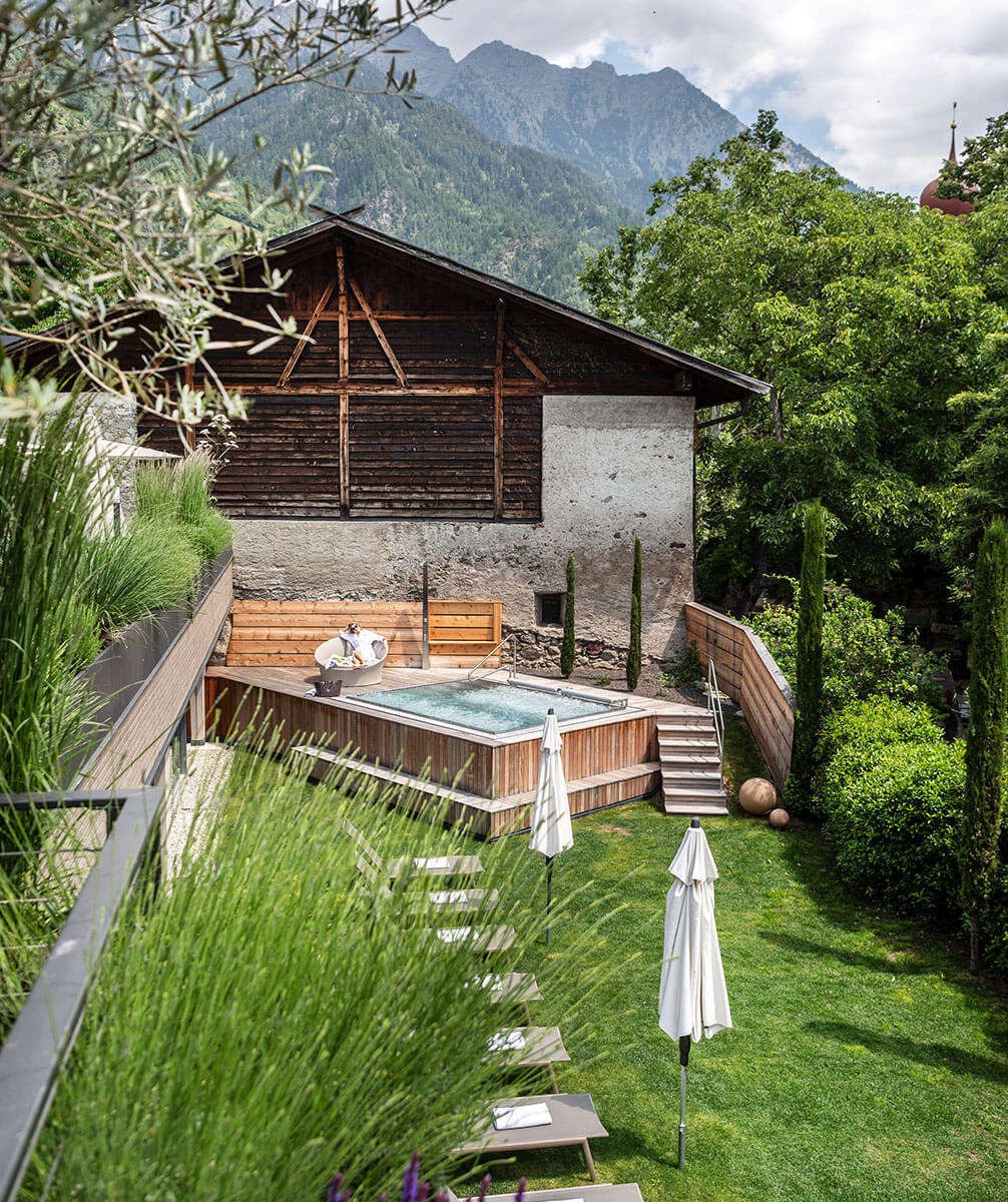 Pool im Garten vor einem Stall im Hintergrund Berge