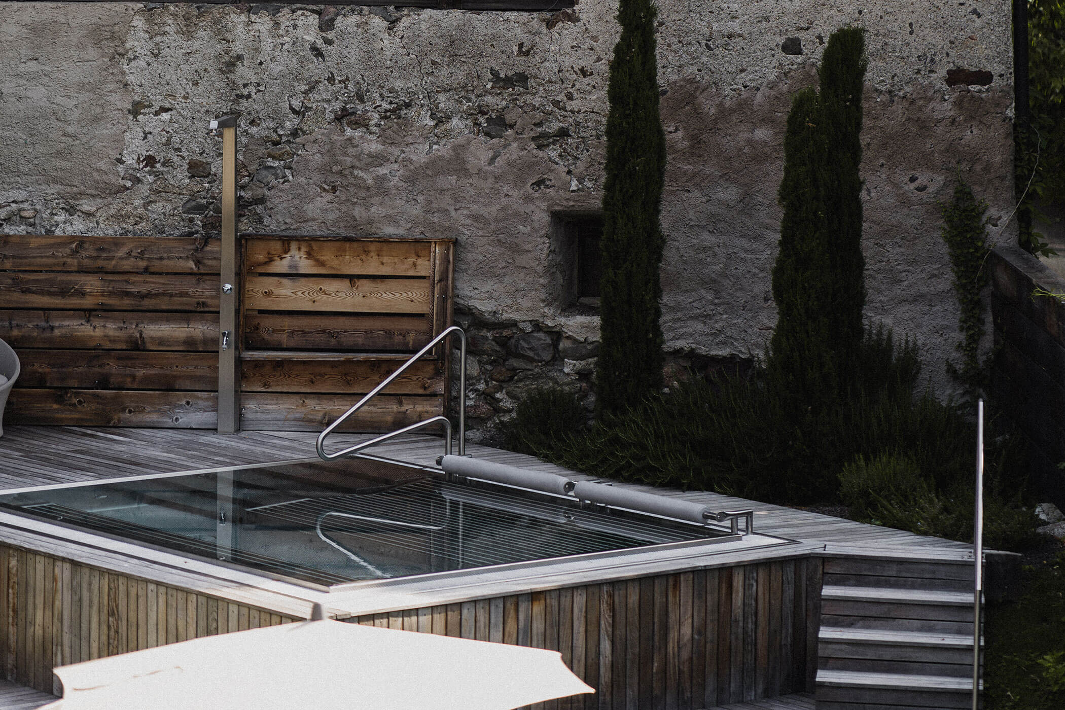 Pool im Garten vor grauen Wand