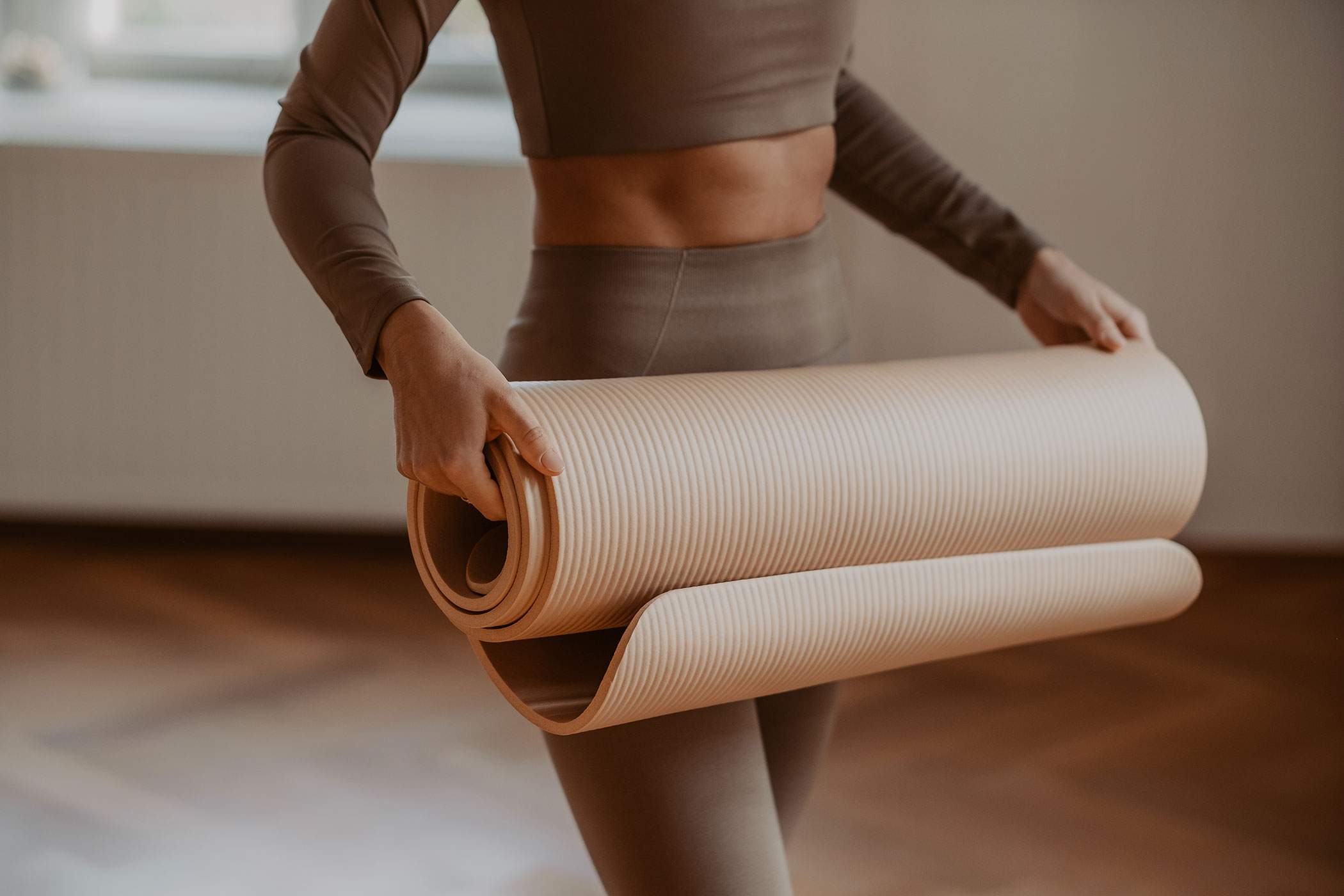 Frau trägt Yogamatte